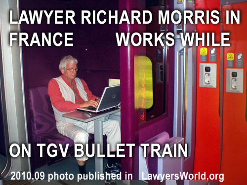 Photo of Richard Morris working on his laptop commputer while on TGV French Bullet  Train wainting to return to Paris