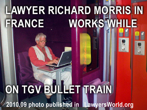 Photo of Richard Morris working on his laptop commputer while on TGV French Bullet  Train wainting to return to Paris